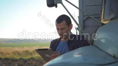 农民靠在卡车上使用数字平板电脑。